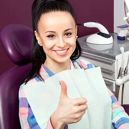 Woman Giving Thumbs Up In Dental Chair